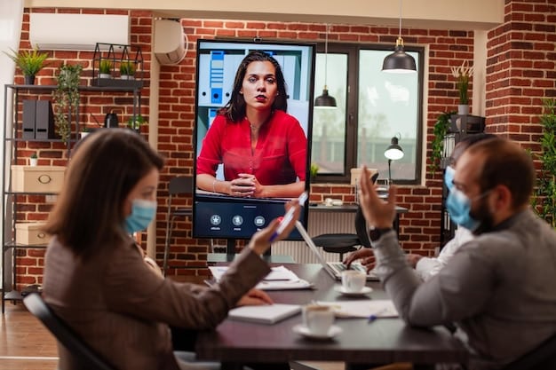 A manager holding a virtual meeting with her remote team. Each team member is visible in a separate window, with the manager addressing the group with enthusiasm and confidence.