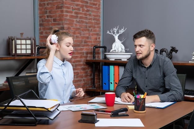 A manager sitting at their desk, calmly and empathetically listening to an employee who is expressing frustration or concern. The scene highlights the manager's ability to remain composed and supportive despite the potentially tense situation.