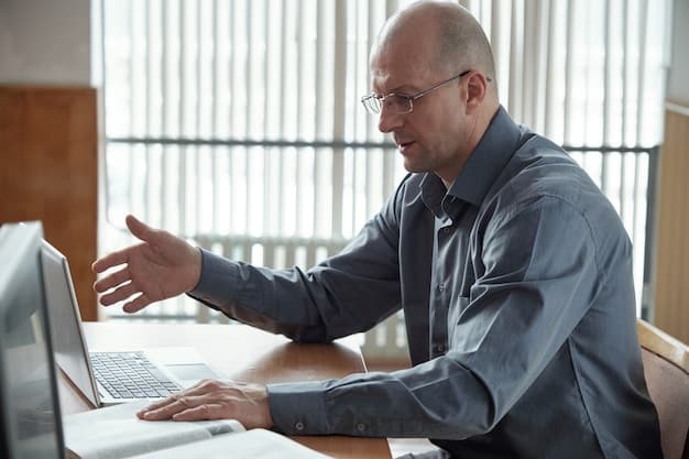 A manager sitting at a desk, reviewing performance data on a laptop. The office setting is clean and professional, with a focus on data-driven insights.