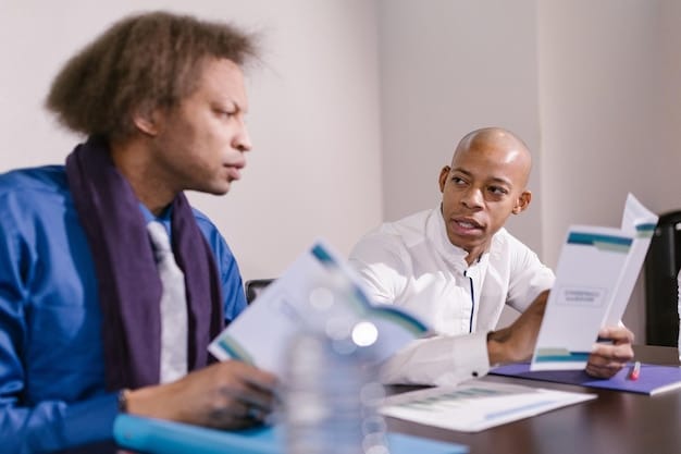 Two co-founders are sitting at a desk, intensely focused on a collaborative document displayed on a laptop screen. They are gesturing and discussing the content, highlighting real-time editing and feedback.