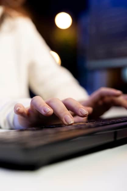 A close-up shot of hands typing on a laptop, with code visible on the screen. The focus is on the screen and the hands, with a blurred background of an office environment.
