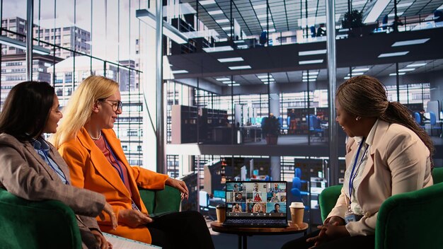 A diverse group of professionals collaborating in a modern, hybrid office setting, with digital tools and screens illustrating seamless connectivity.