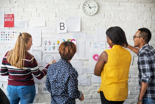 A diverse group of startup employees brainstorming around a whiteboard filled with complex diagrams of AI algorithms and compliance checklists, illustrating the challenge of balancing innovation with regulation.