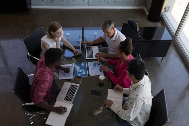 A diverse group of startup employees brainstorming in a modern, open-plan office, with quantum-themed graphics subtly displayed on a screen in the background, conveying innovation and collaboration.