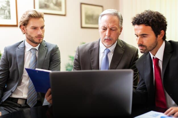 A legal professional explaining complex labor law updates to a small group of attentive business owners in a modern, well-lit conference room, using a presentation screen to highlight key legal clauses.