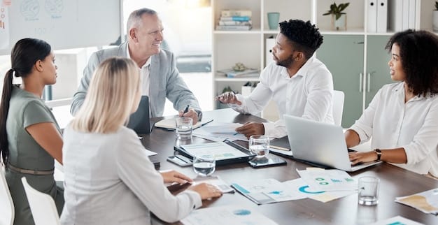 A diverse group of business professionals in a modern office collaborating around a table, reviewing documents and discussing compliance strategies, conveying teamwork and proactive planning.